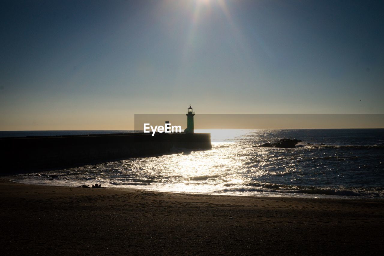 LIGHTHOUSE AMIDST SEA AGAINST SKY