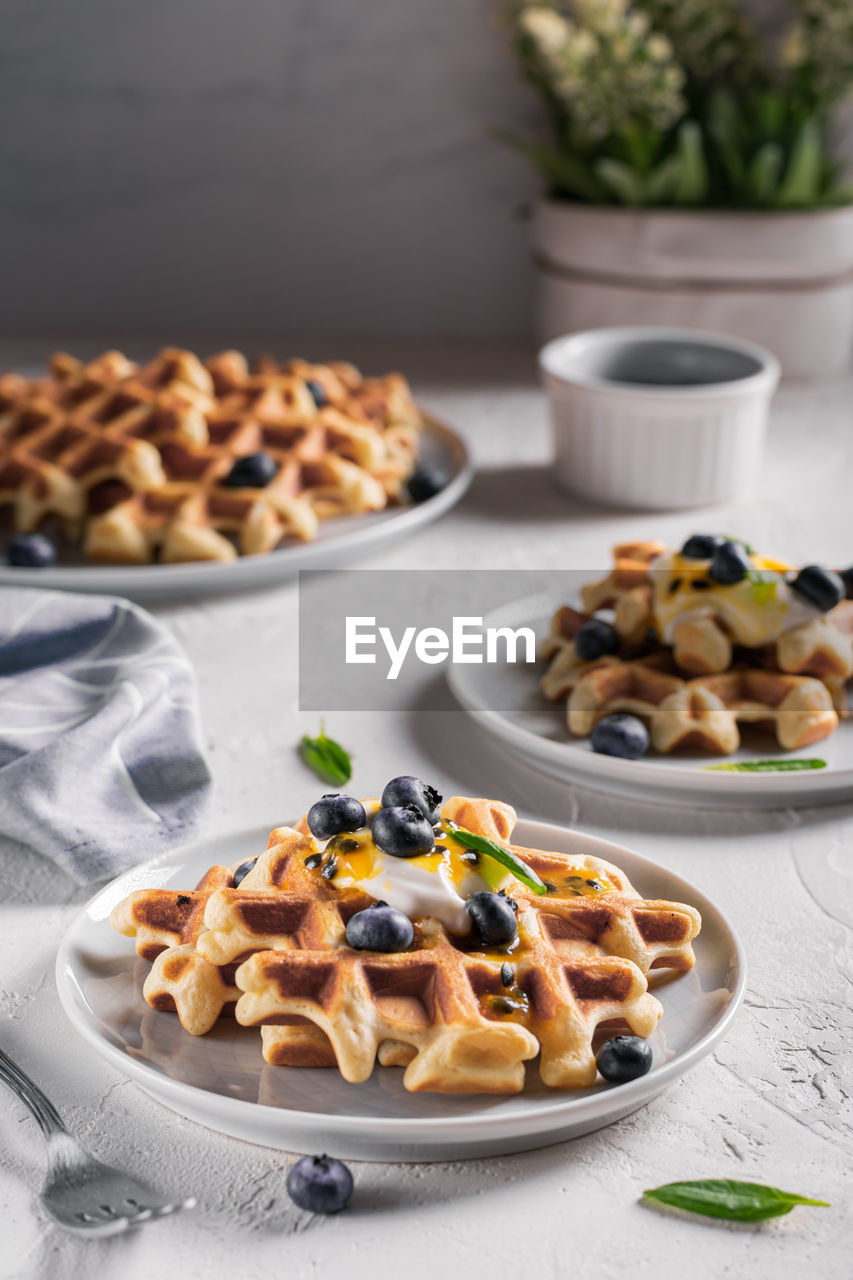 Breakfast with waffles with blueberries and syrup on a plates