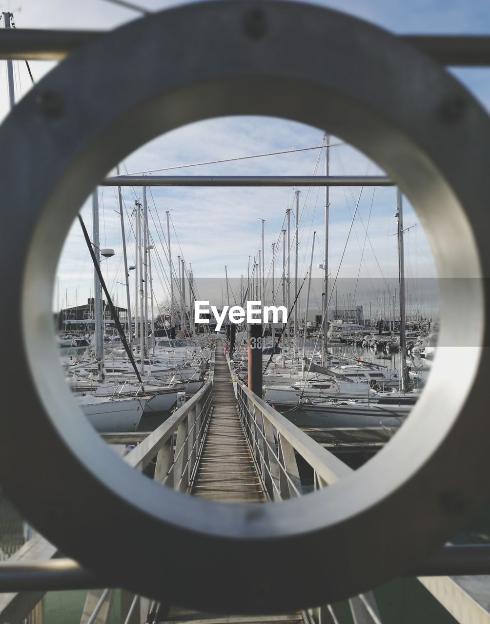 Boats moored at harbor seen through hole