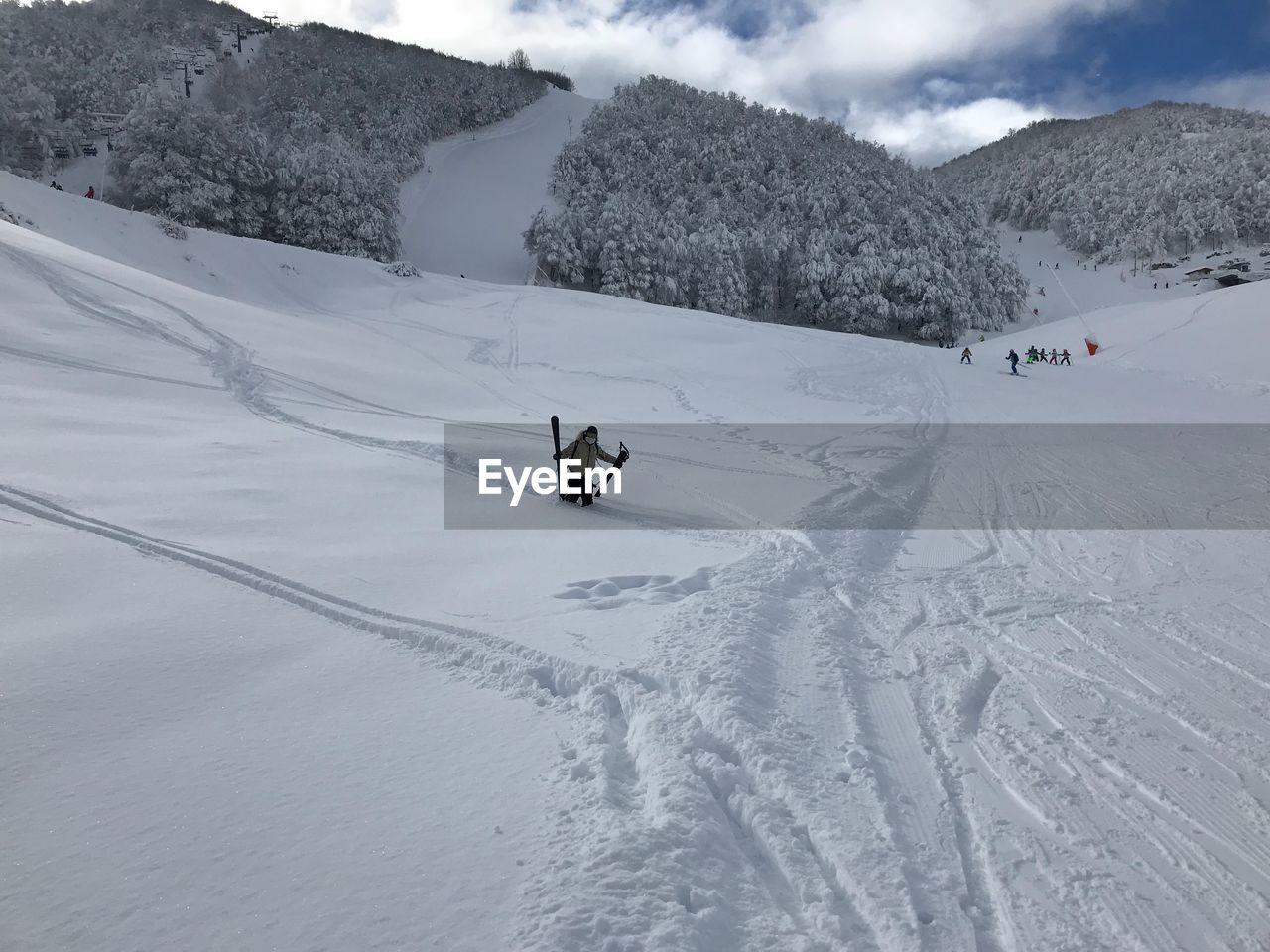 Hiker with skis standing on snow covered mountain