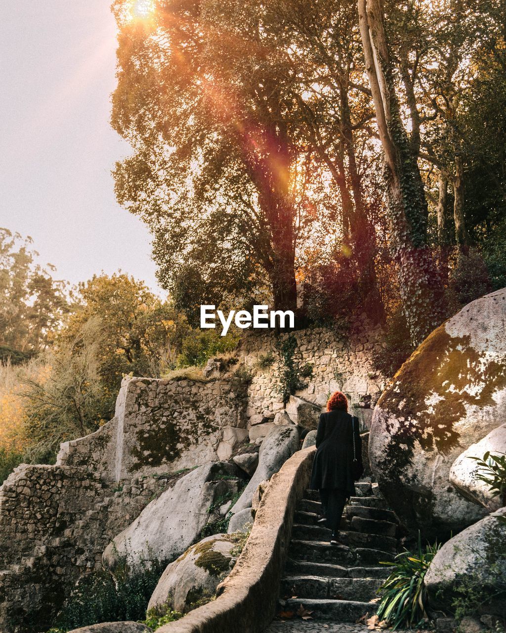 MAN STANDING ON ROCK AGAINST SKY