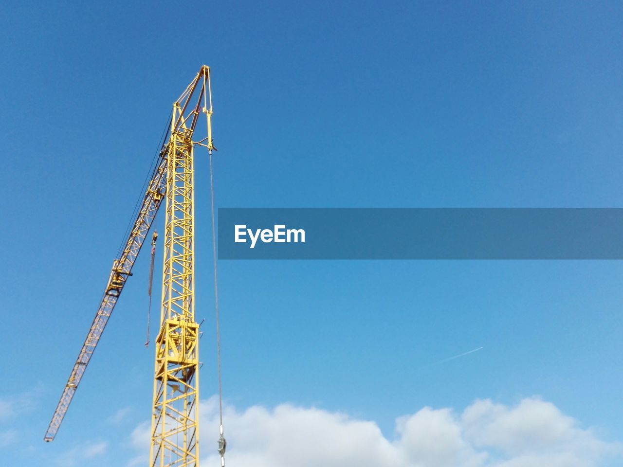 Low angle view of crane against blue sky