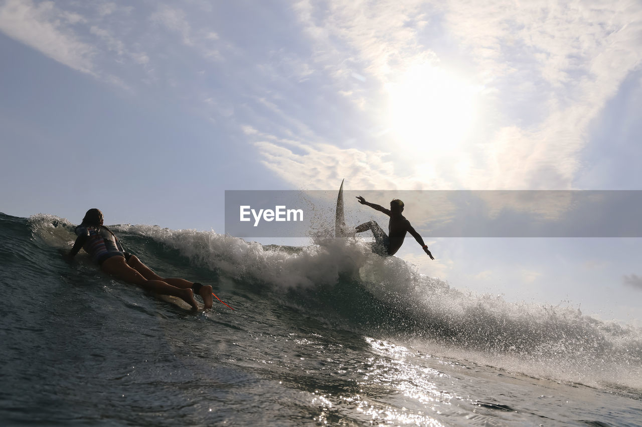 Surfer on a wave at sunset time