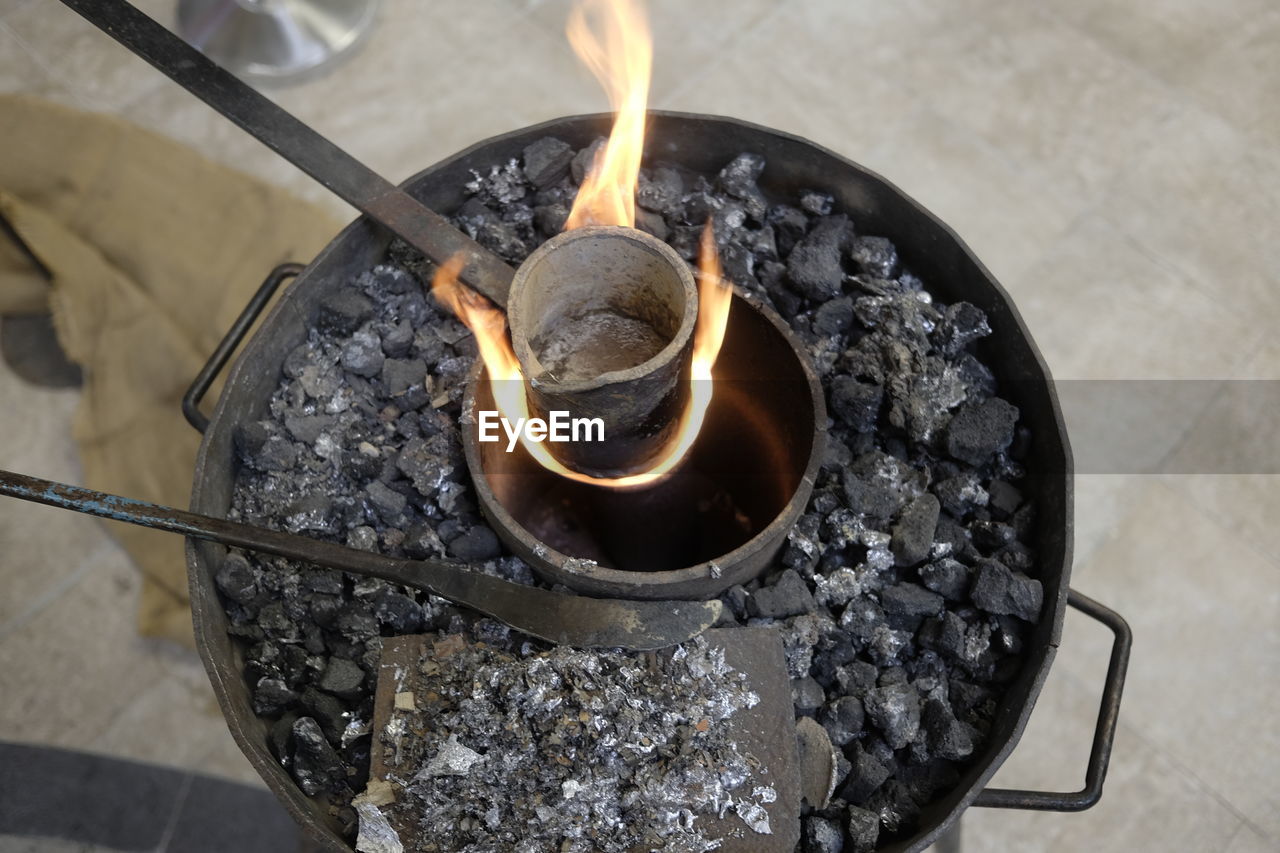 Close-up high angle view of container burning on coal