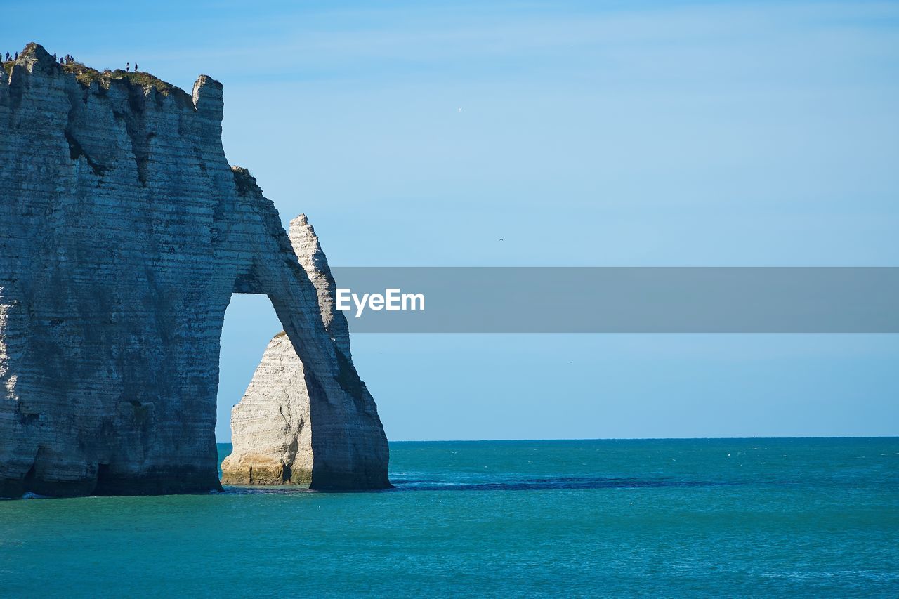 SCENIC VIEW OF ROCK FORMATION IN SEA AGAINST BLUE SKY