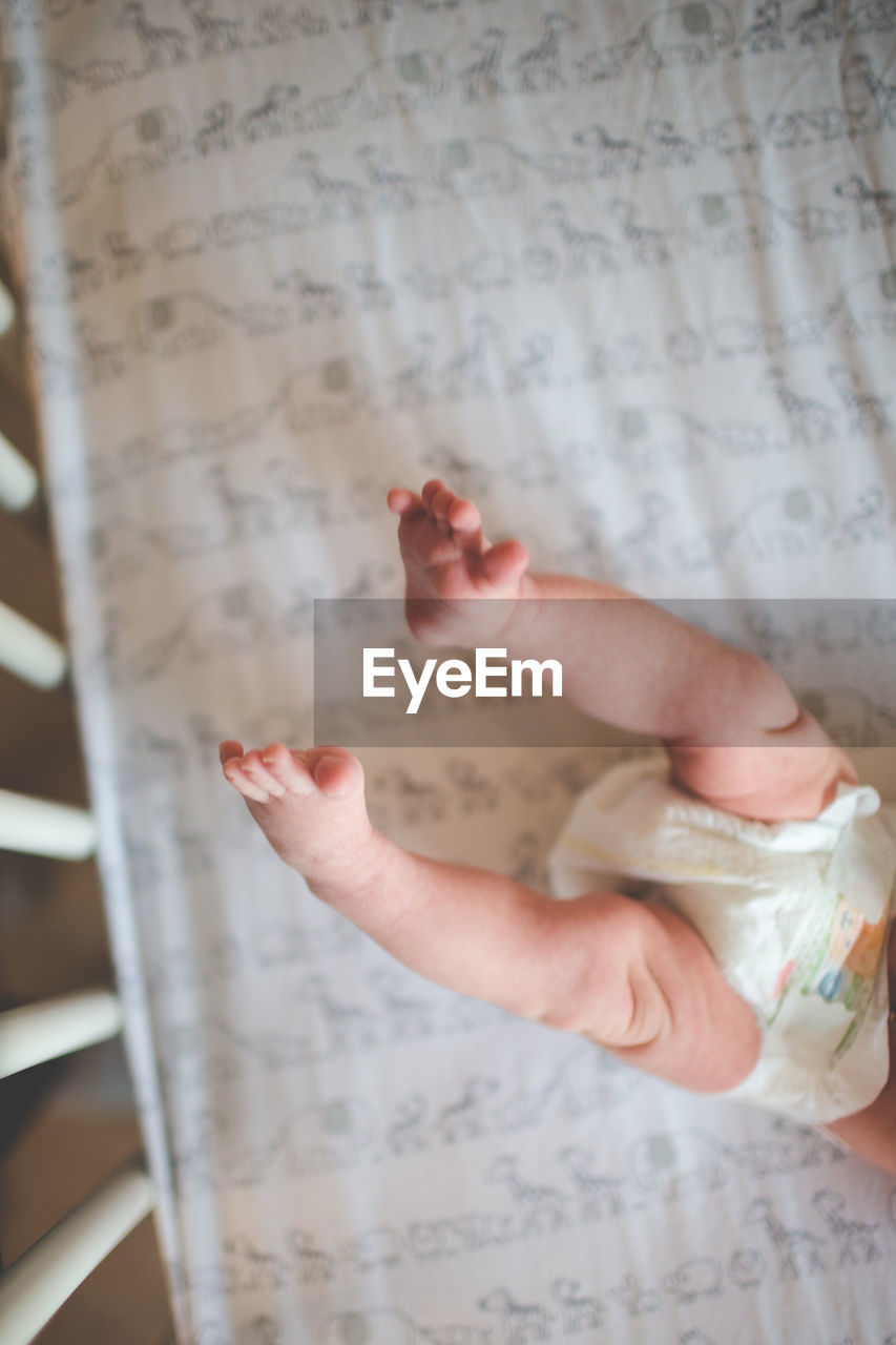 Low section of baby girl in crib