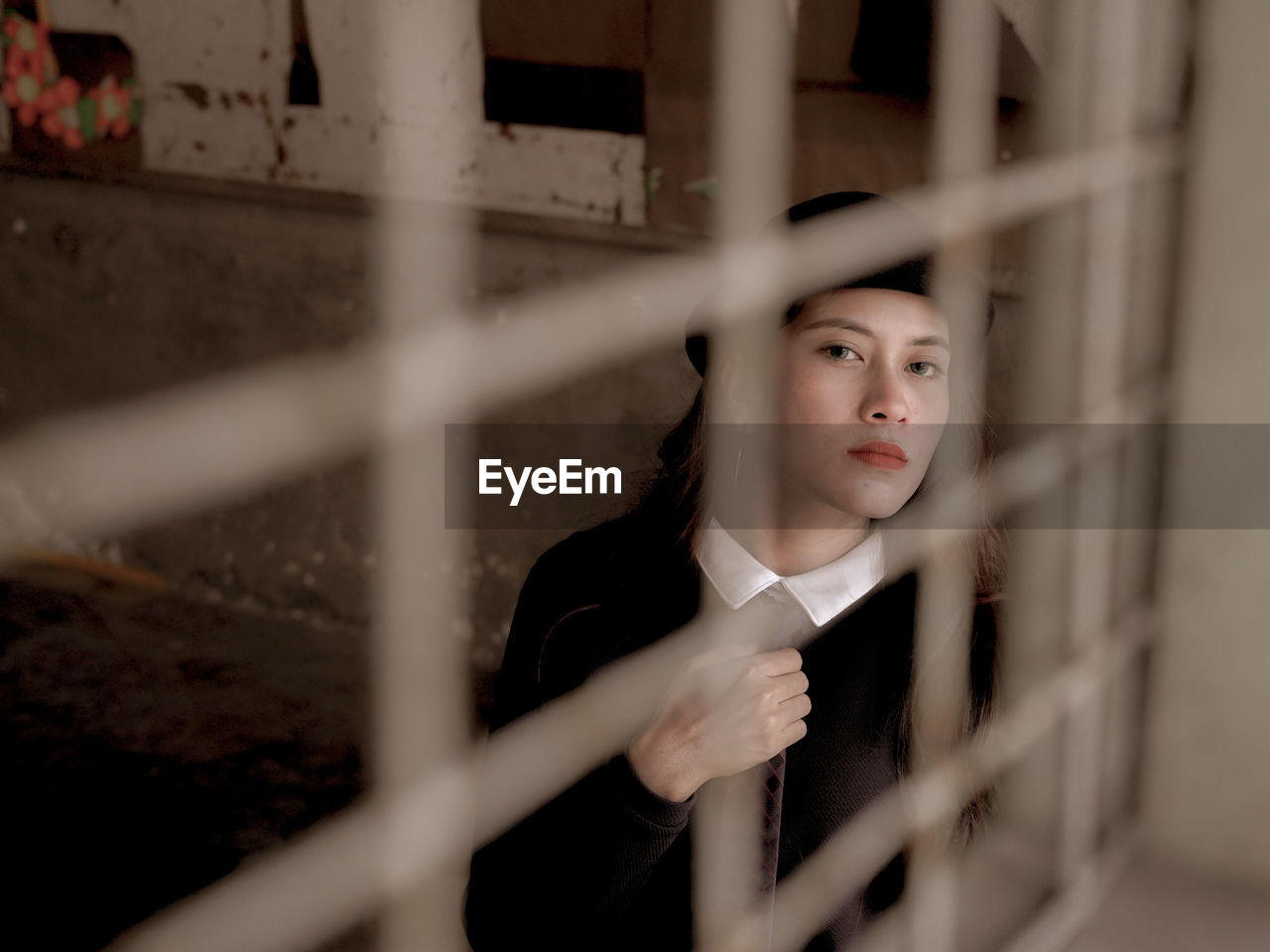 Portrait of young woman looking through window