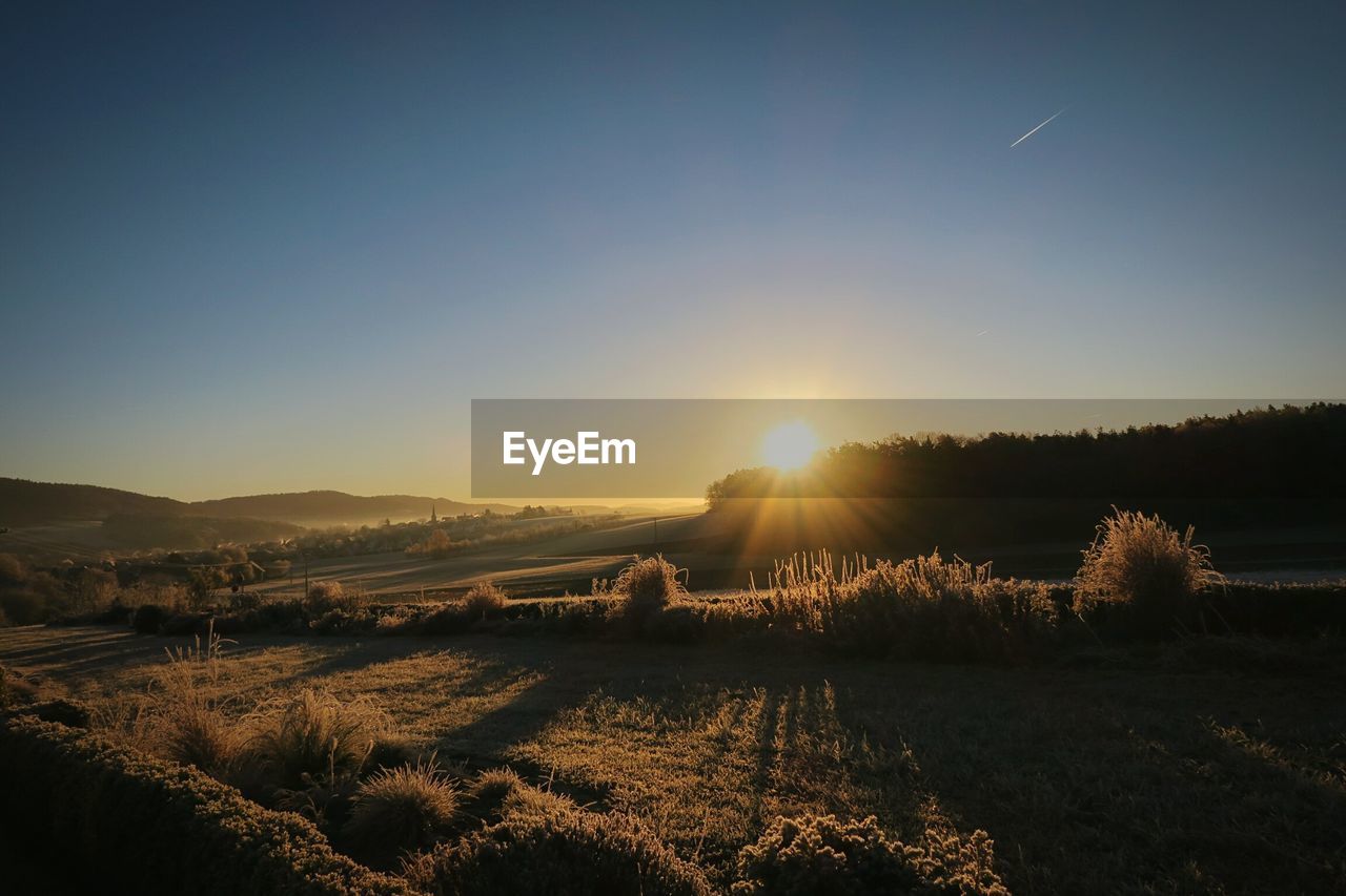 SCENIC VIEW OF SUNSET OVER FIELD