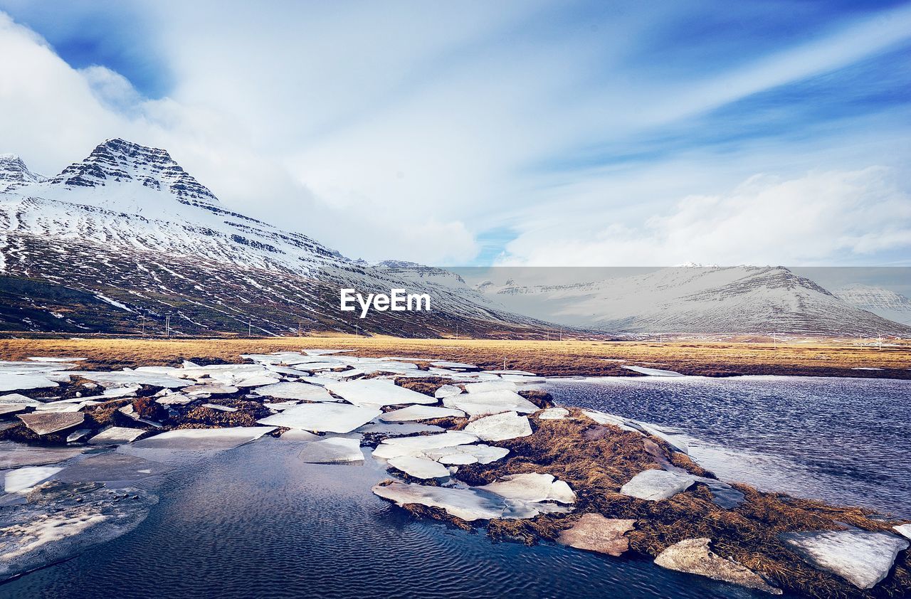 SCENIC VIEW OF LAKE AGAINST SNOWCAPPED MOUNTAINS