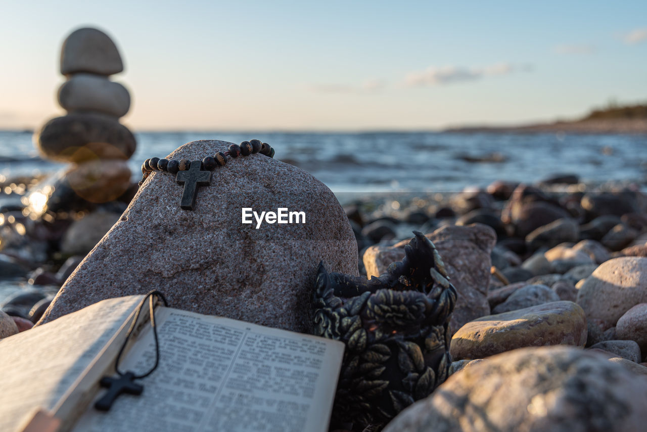 A bible and cross by the sea that has become a new place to pray with little people