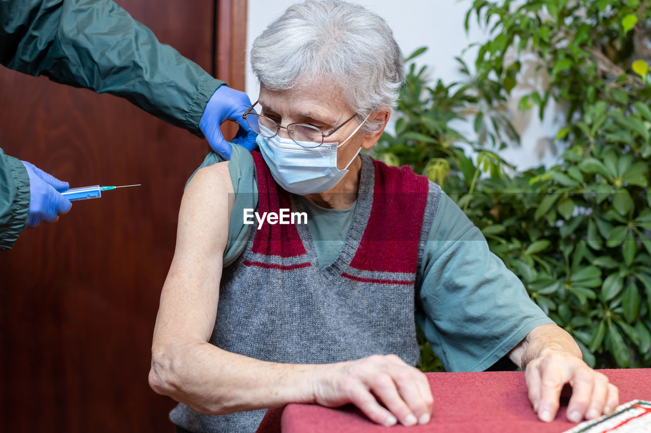 Senior woman receiving the vaccine in nursing home