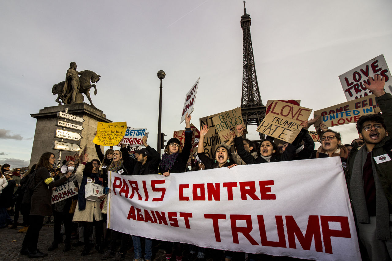 GROUP OF PEOPLE ON STREET IN CITY AGAINST SKY IN BACKGROUND