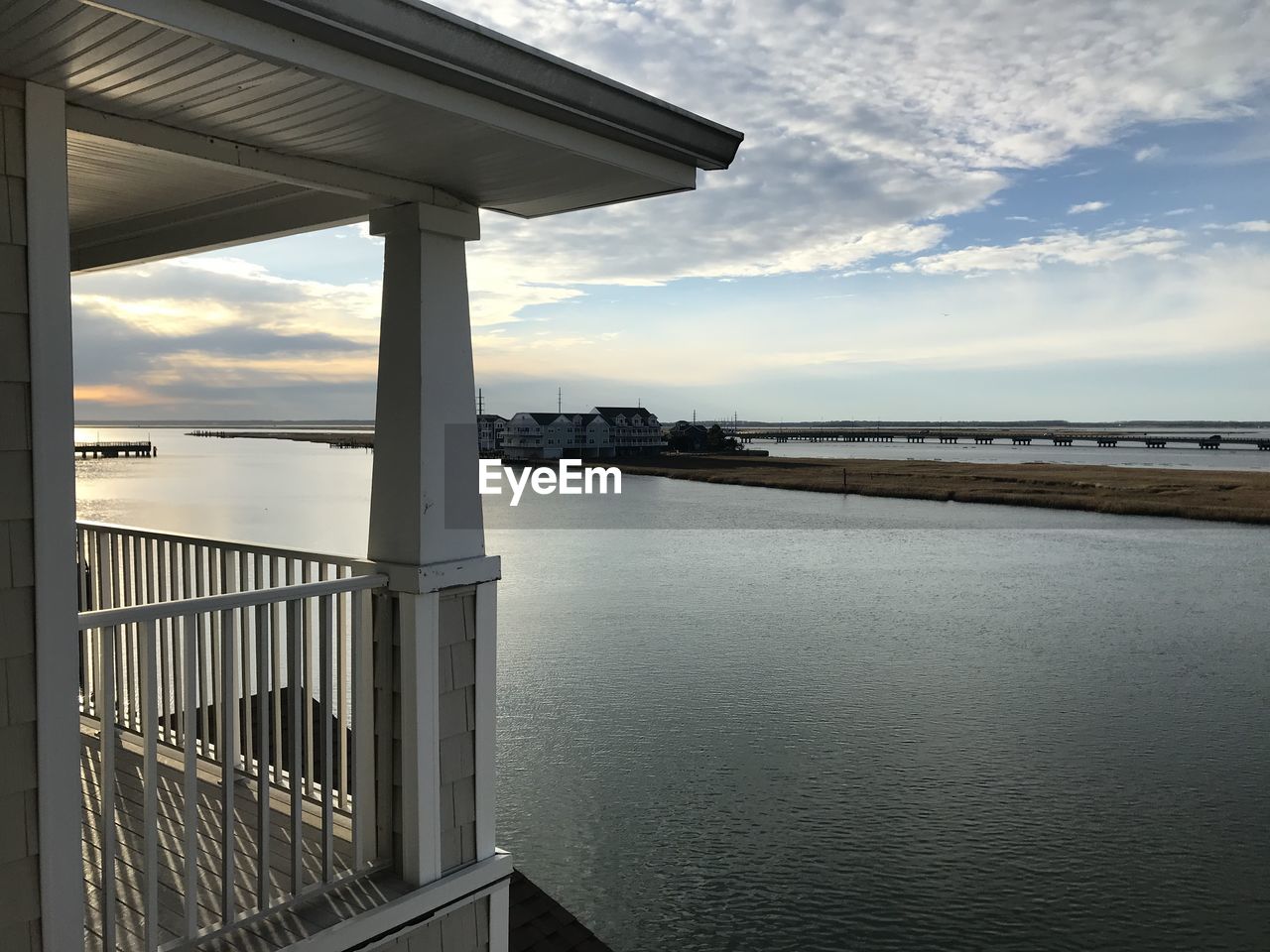 water, sky, architecture, cloud, built structure, sea, nature, reflection, scenics - nature, railing, no people, beauty in nature, tranquility, sunset, outdoors, beach, building exterior, tranquil scene, bridge, horizon, city, day, building, land, horizon over water, travel destinations, travel