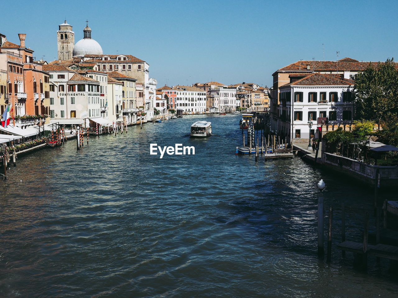 Canal amidst buildings in city against clear sky