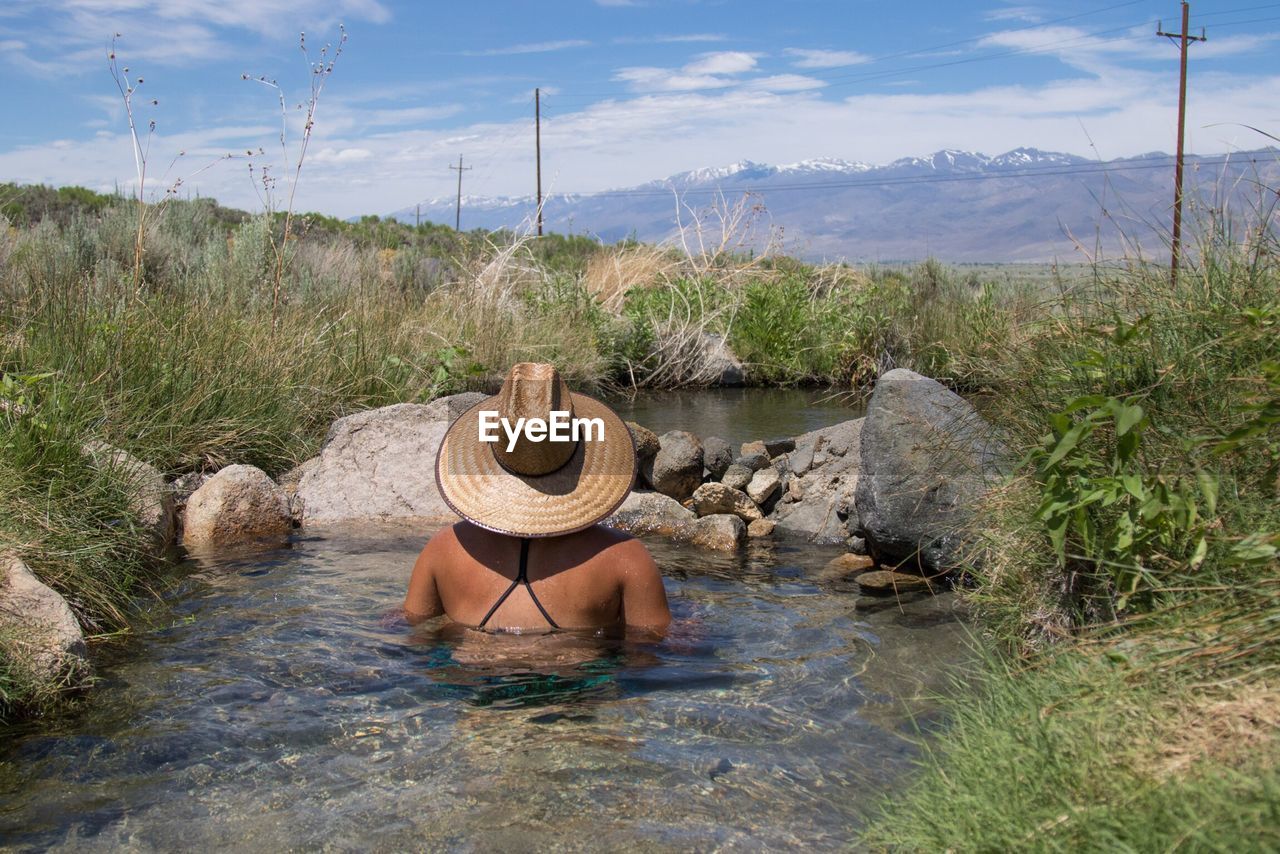 Rear view of woman in small pond