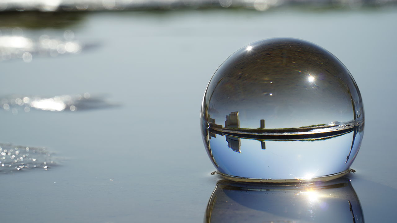 CLOSE-UP OF CRYSTAL BALL IN CALM WATER