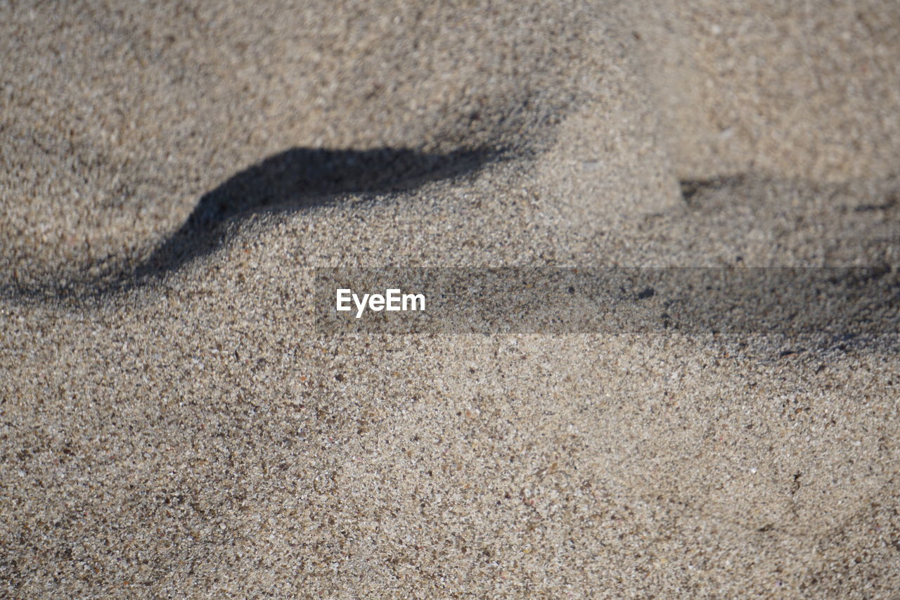 HIGH ANGLE VIEW OF SAND SHADOW ON CONCRETE