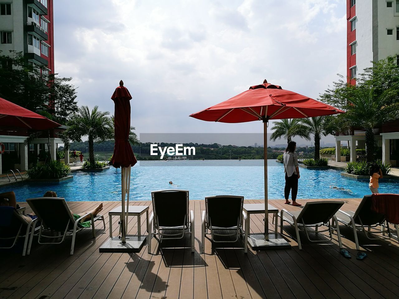 CHAIRS AND TABLES BY SWIMMING POOL IN CITY