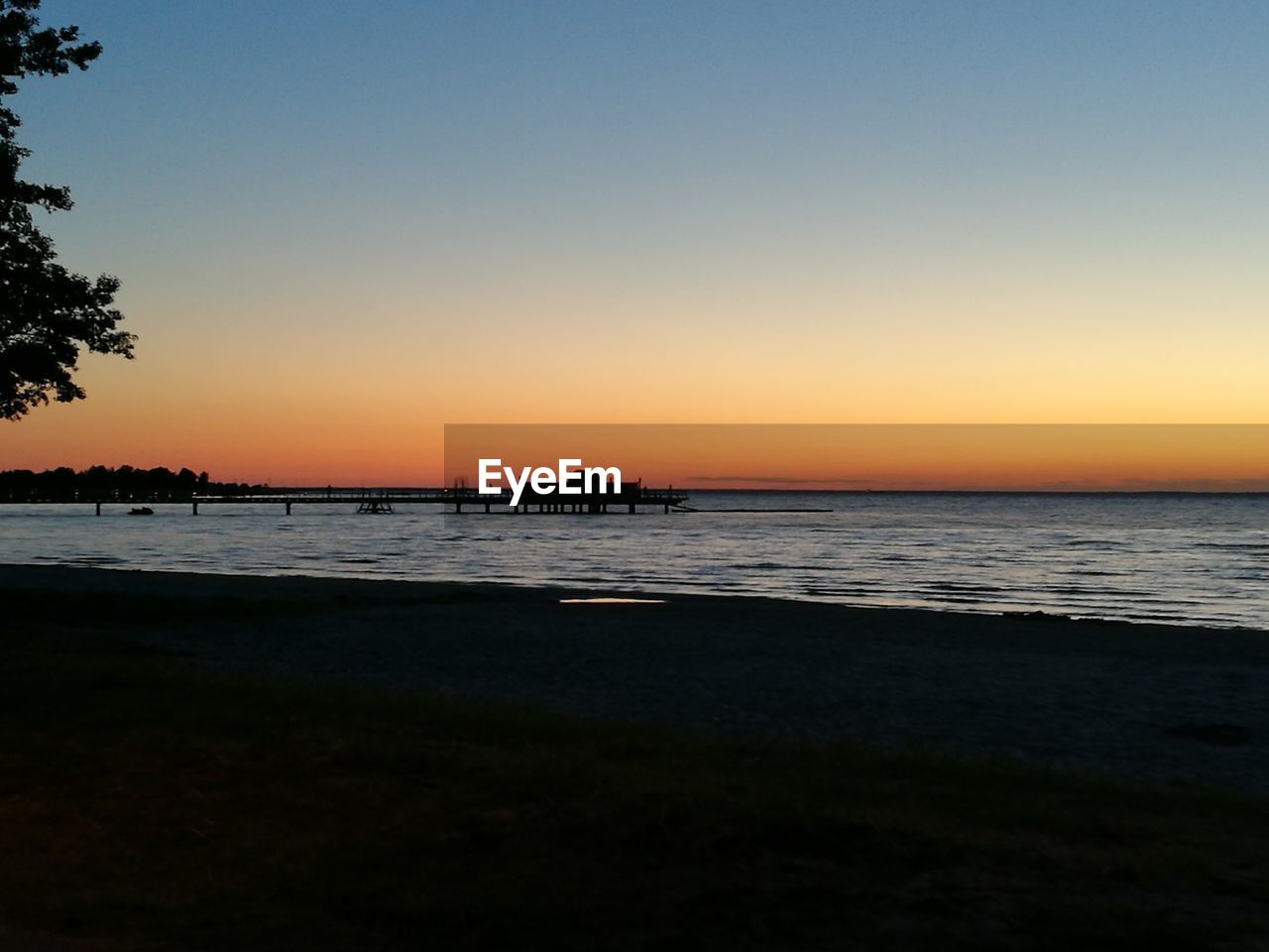 SCENIC VIEW OF BEACH AGAINST CLEAR SKY DURING SUNSET