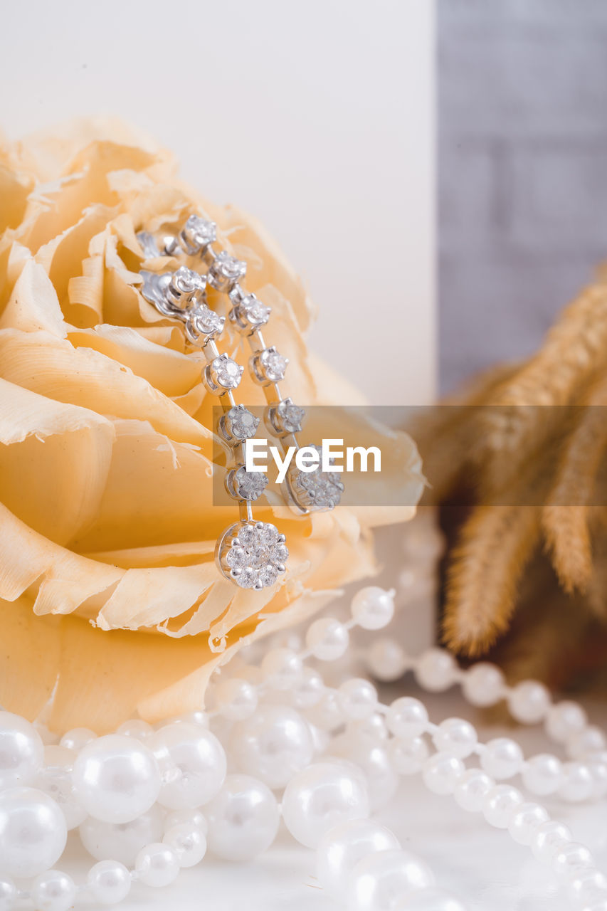 yellow, flower, celebration, event, bouquet, jewelry, petal, wedding, fashion accessory, pearl jewelry, decoration, elegance, indoors, luxury, white, close-up, no people, jewellery, plant, wealth, nature, fashion, selective focus, beauty in nature