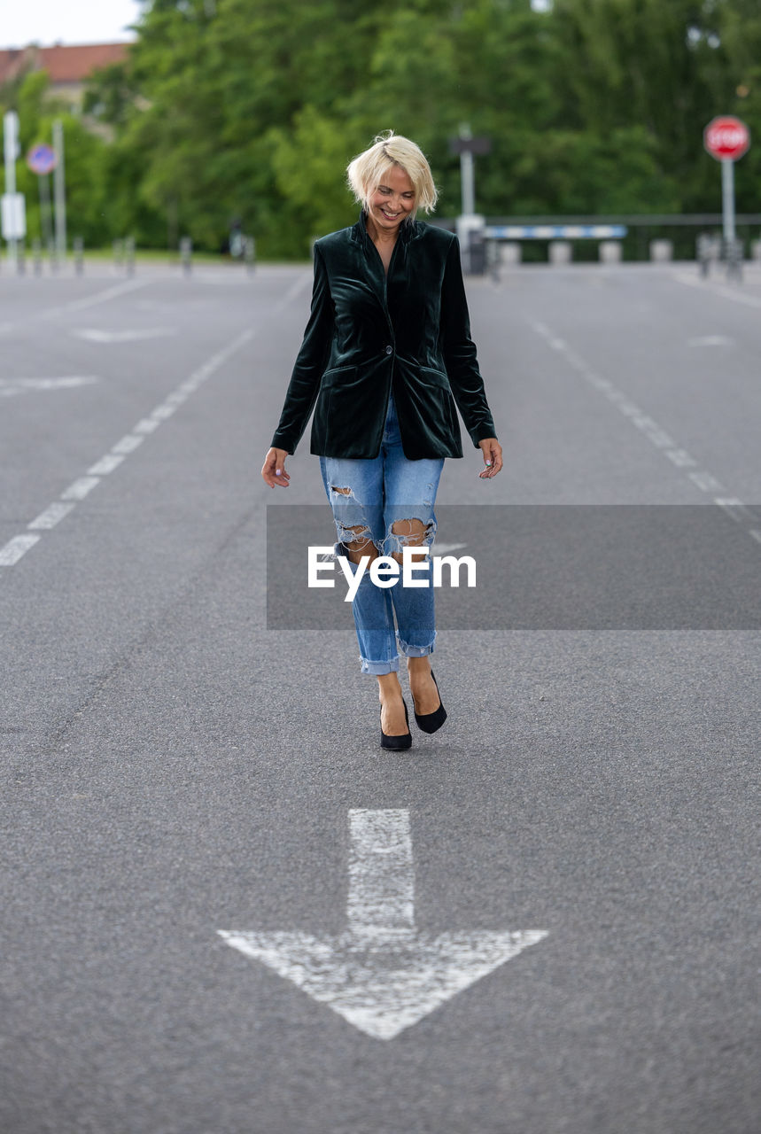 full length of young woman standing on road