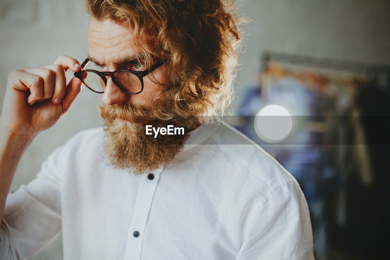 Fashion designer looking away while standing in workshop