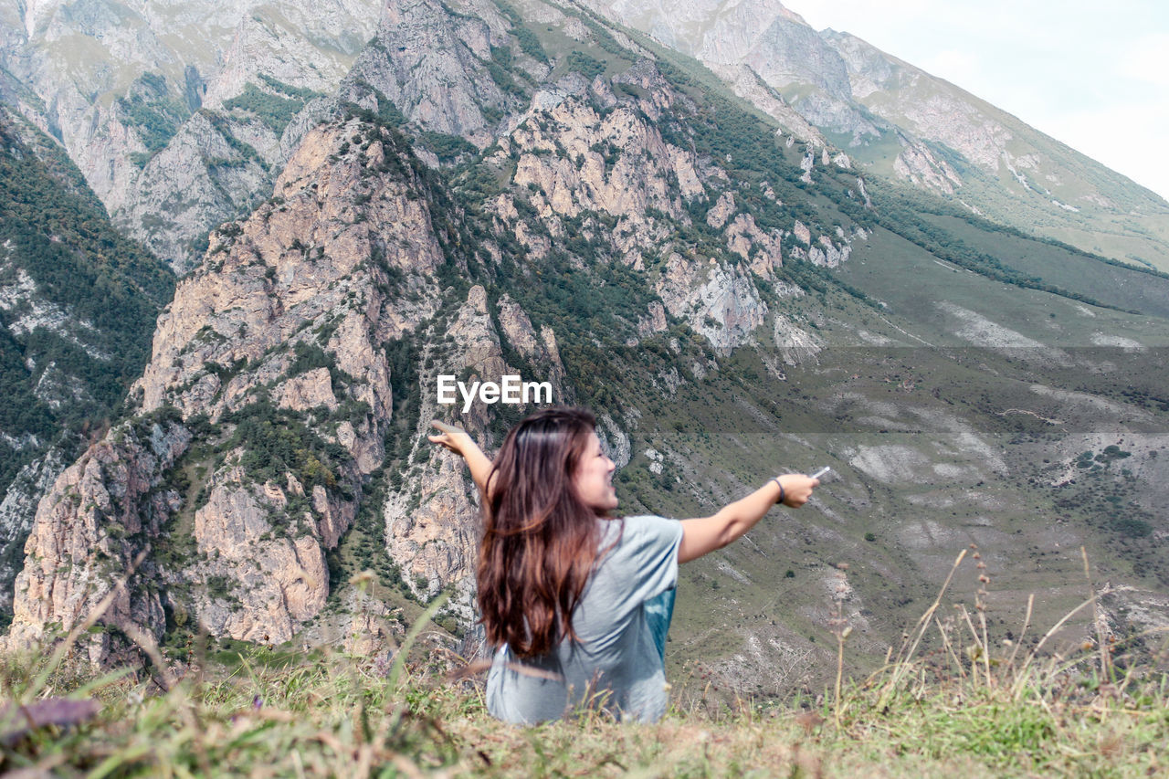 YOUNG MAN STANDING ON MOUNTAIN