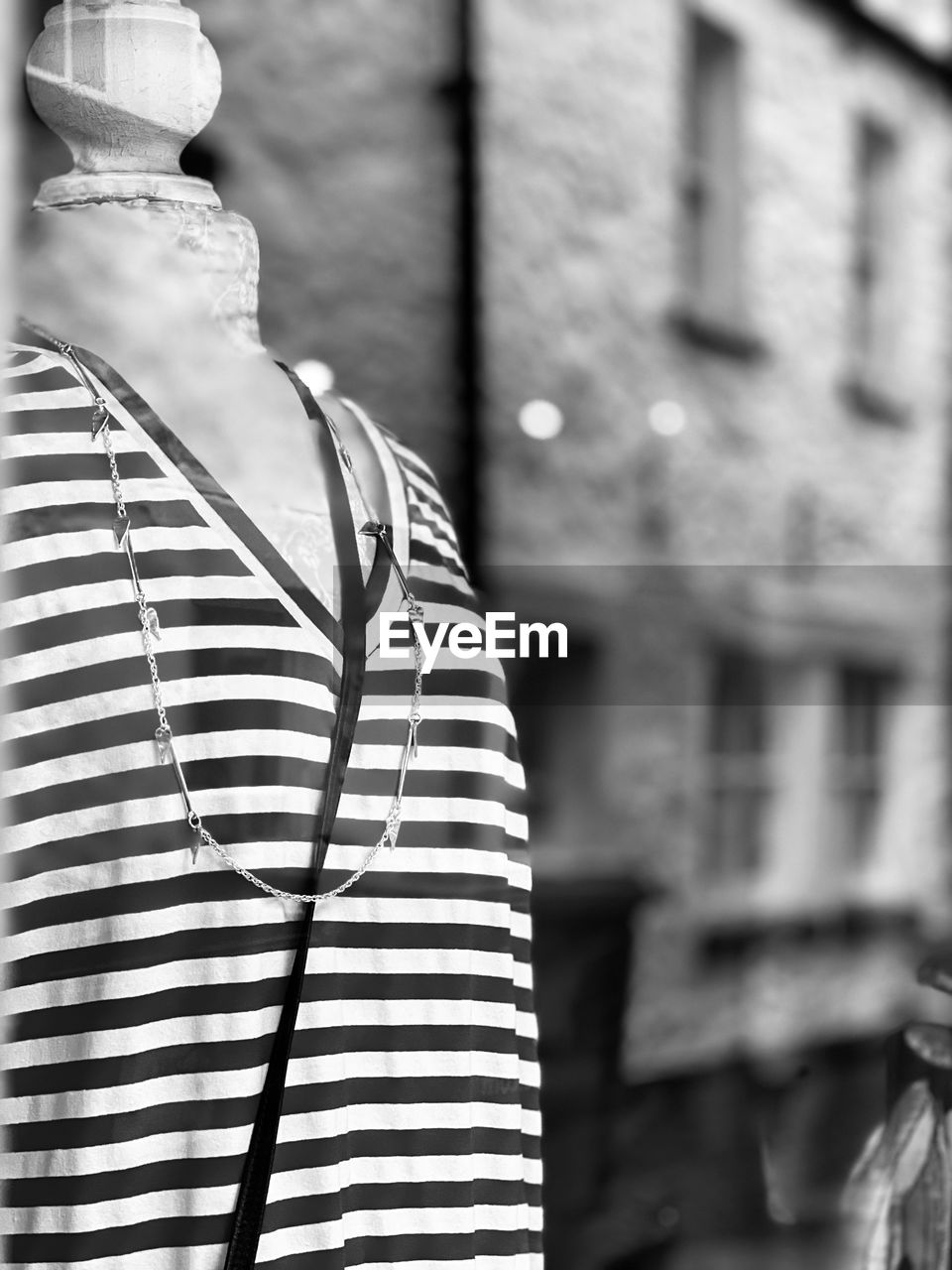 white, black and white, striped, monochrome photography, black, architecture, monochrome, focus on foreground, clothing, building exterior, day, city, built structure, outdoors, spring, hat, no people, casual clothing, retail