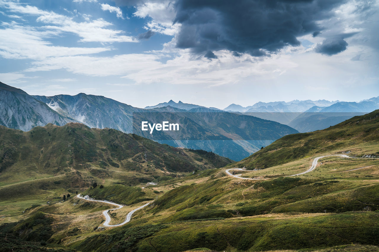 Landscape of aran valley with majestic green hills and dark gray gloomy sky above