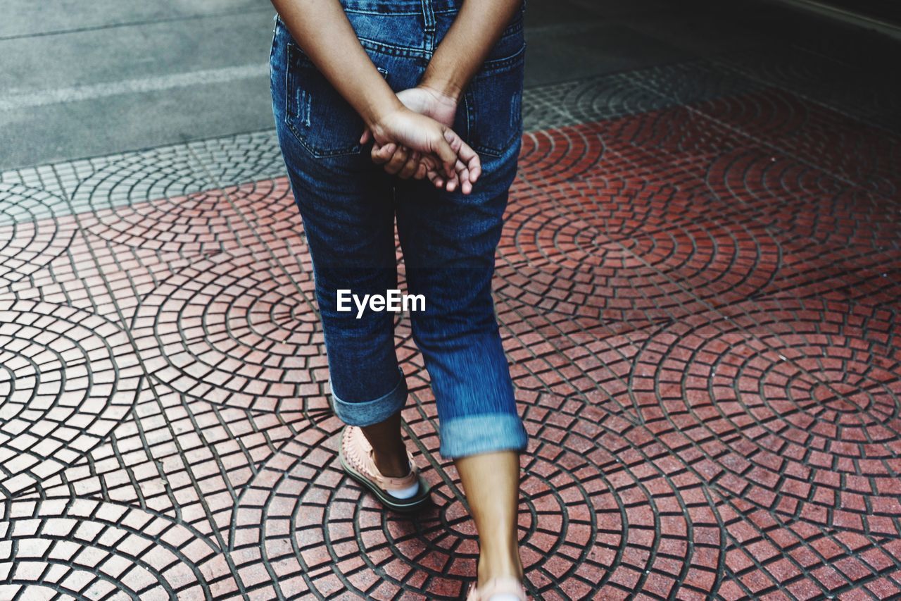 Low section of woman walking on footpath