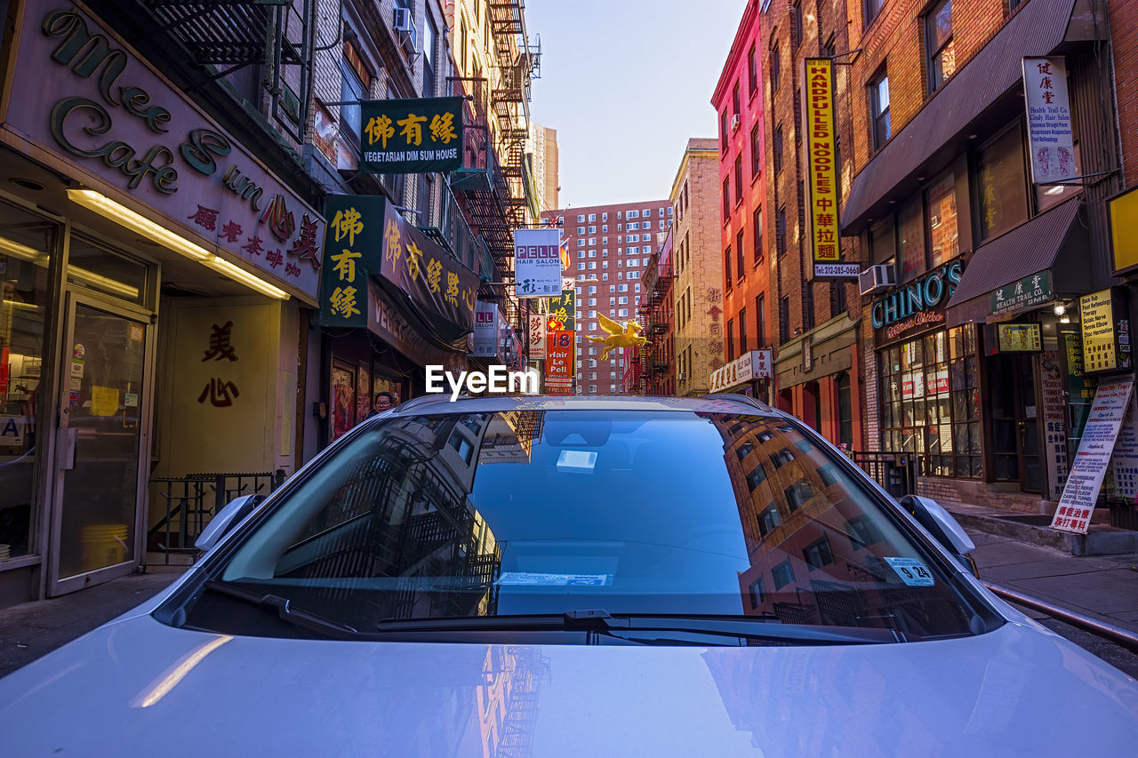 CARS ON ROAD BY BUILDINGS IN CITY