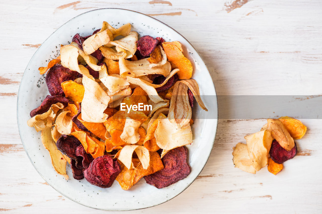 Bowl of healthy snack from vegetable chips, such as sweet potato, beetroot, parsnip, carrots