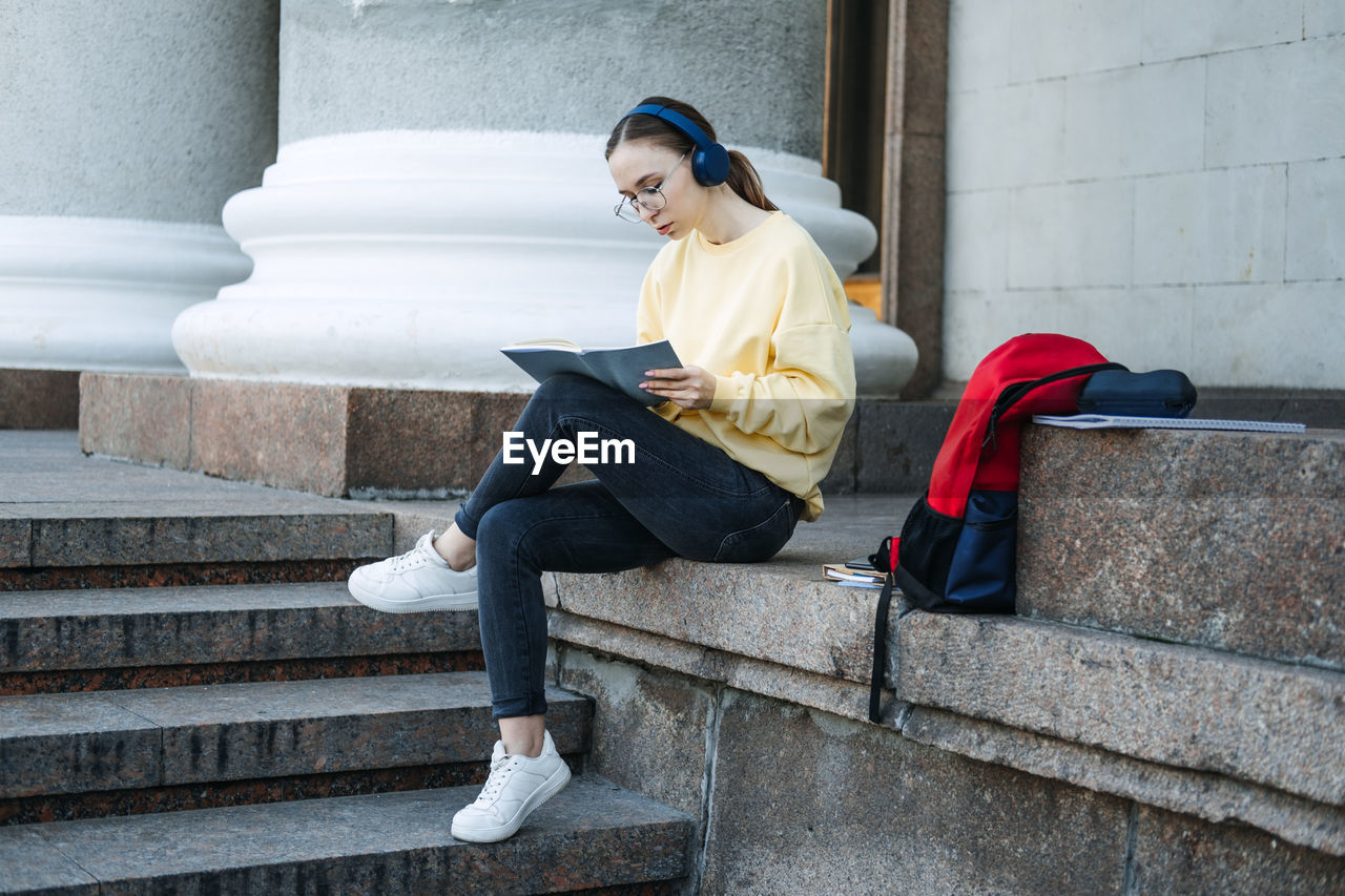 Positive daily affirmations for self love. young woman in headphones writing in notebook