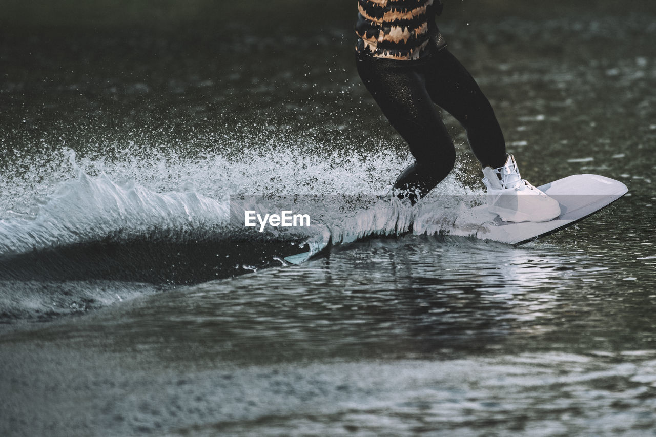 Low section of person surfing in sea