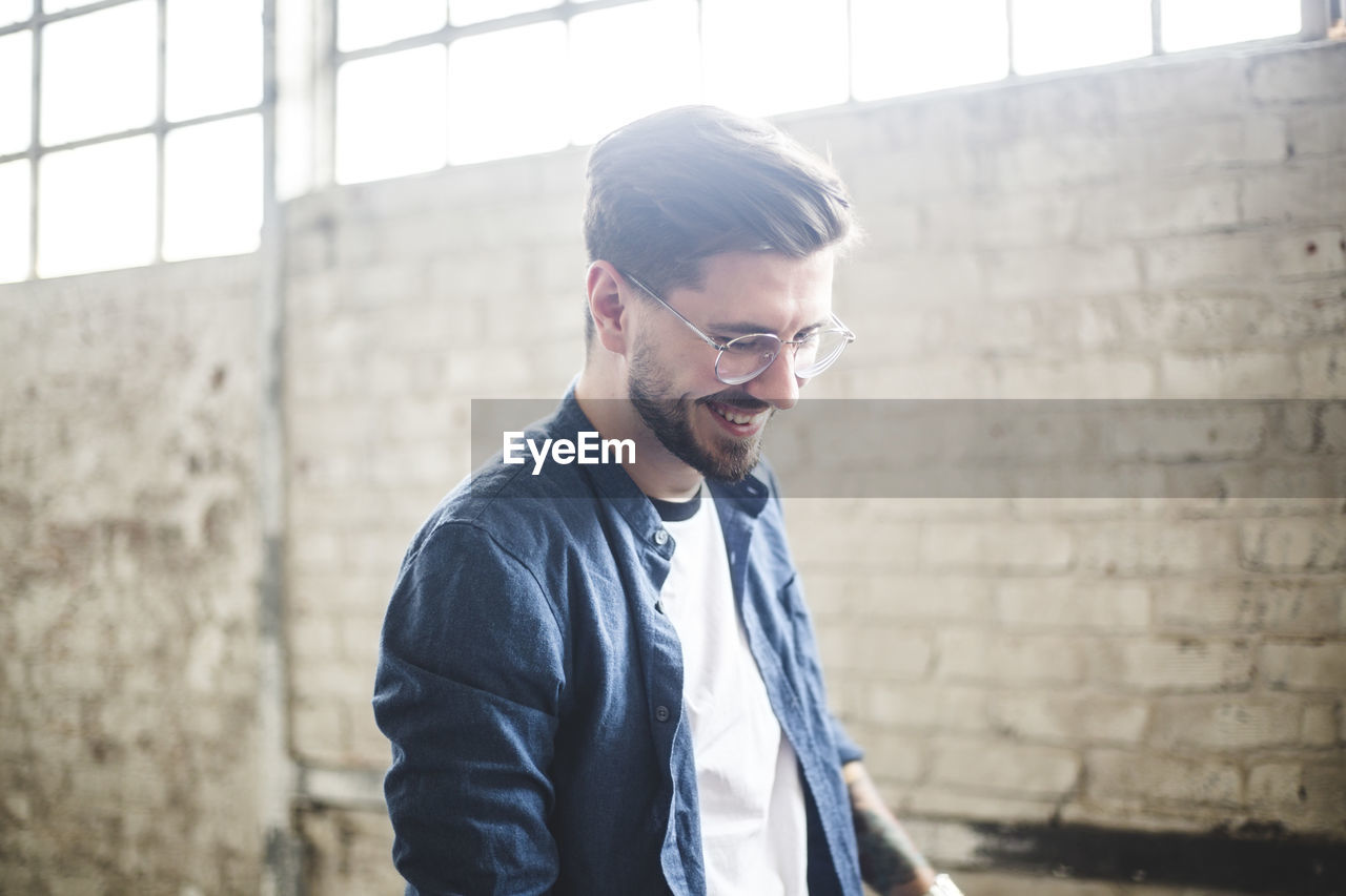 Smiling bearded businessman wearing smart casual while working in it firm