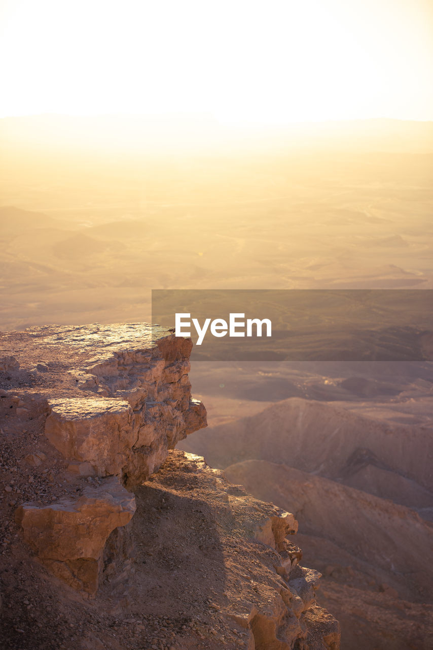 Aerial view of rock formation against sky during sunset