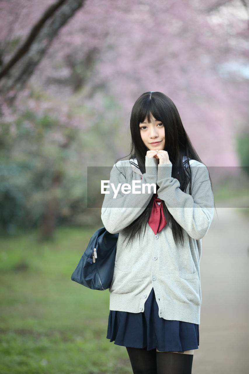 Portrait of a beautiful young woman standing outdoors