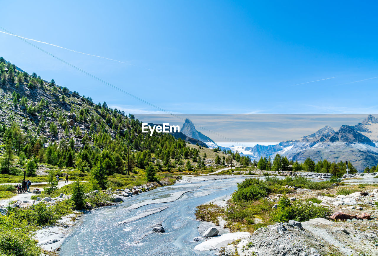 Scenic view of snowcapped mountains against blue sky