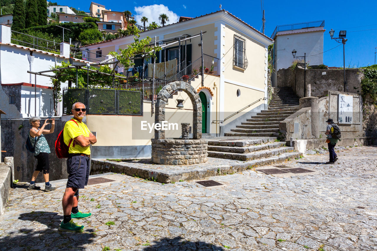 MAN STANDING AGAINST BUILDINGS IN CITY