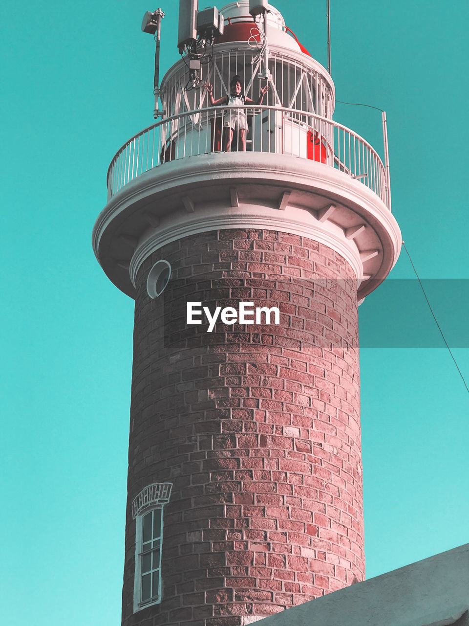 Low angle view of woman standing on lighthouse