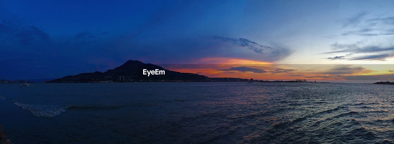 Scenic view of mountain in sea against sky