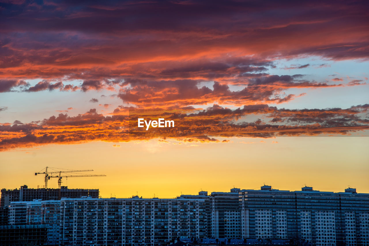 AERIAL VIEW OF BUILDINGS AGAINST DRAMATIC SKY
