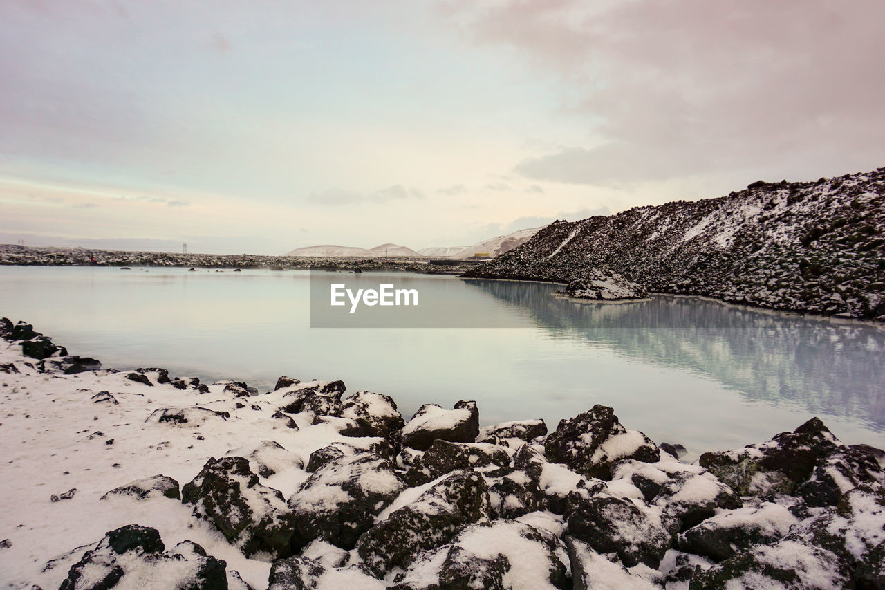 SCENIC VIEW OF SNOWCAPPED MOUNTAINS AND LAKE AGAINST SKY