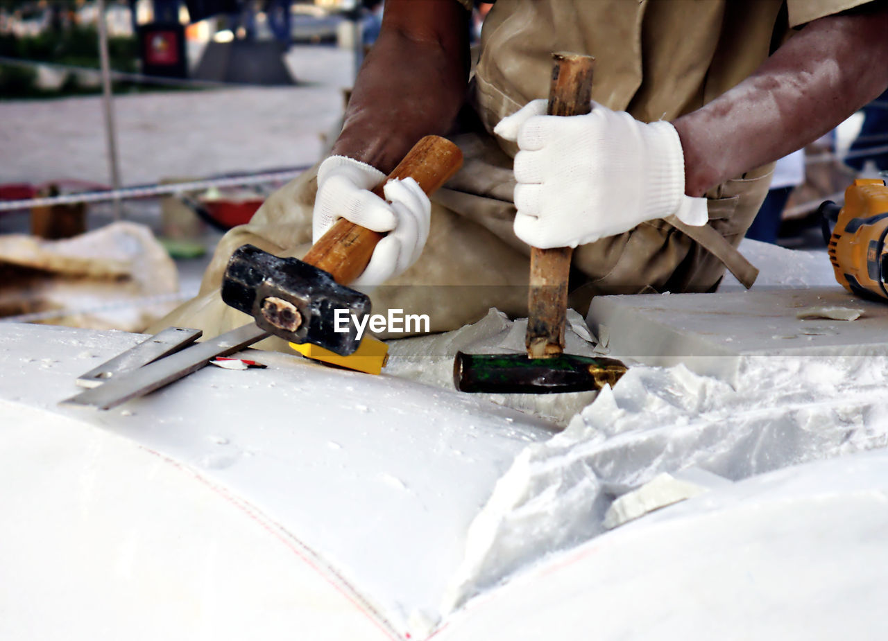 Midsection of worker cutting marble