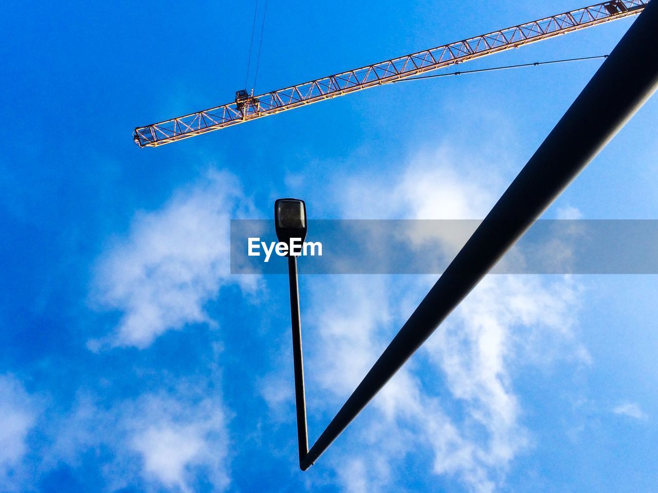 LOW ANGLE VIEW OF STREET LIGHTS AGAINST BLUE SKY