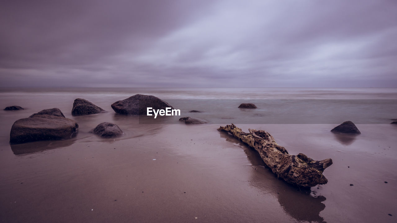 Rocks on sea shore against sky