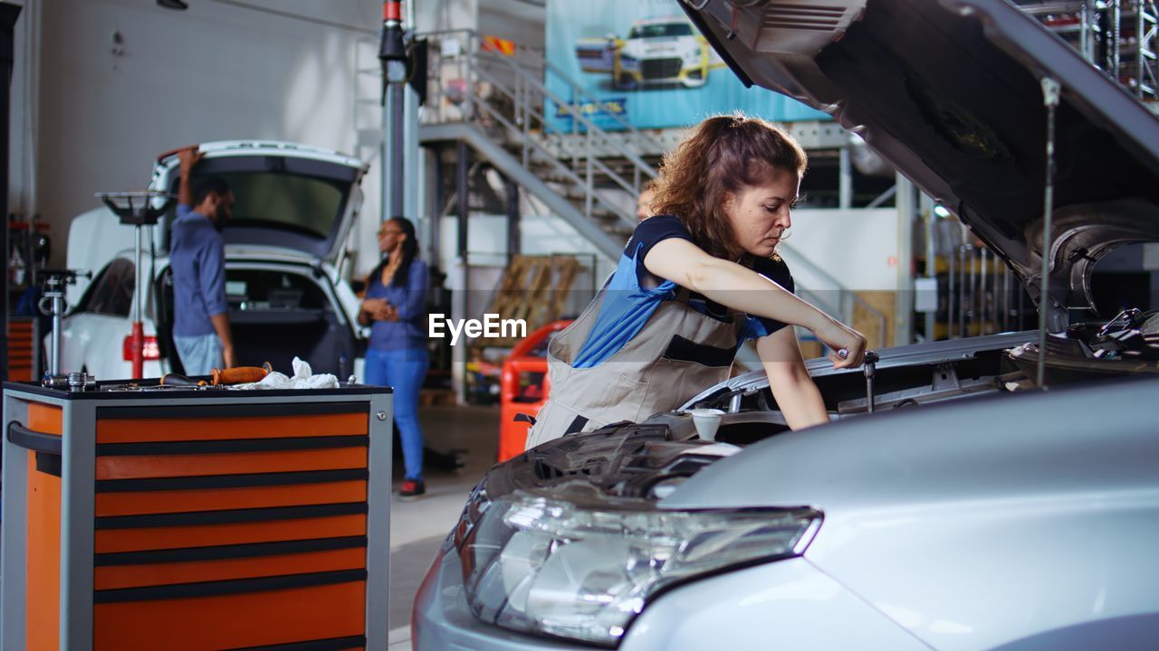 portrait of young woman sitting on car