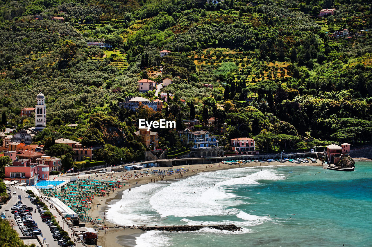 Scenic view of beach by village on mountain