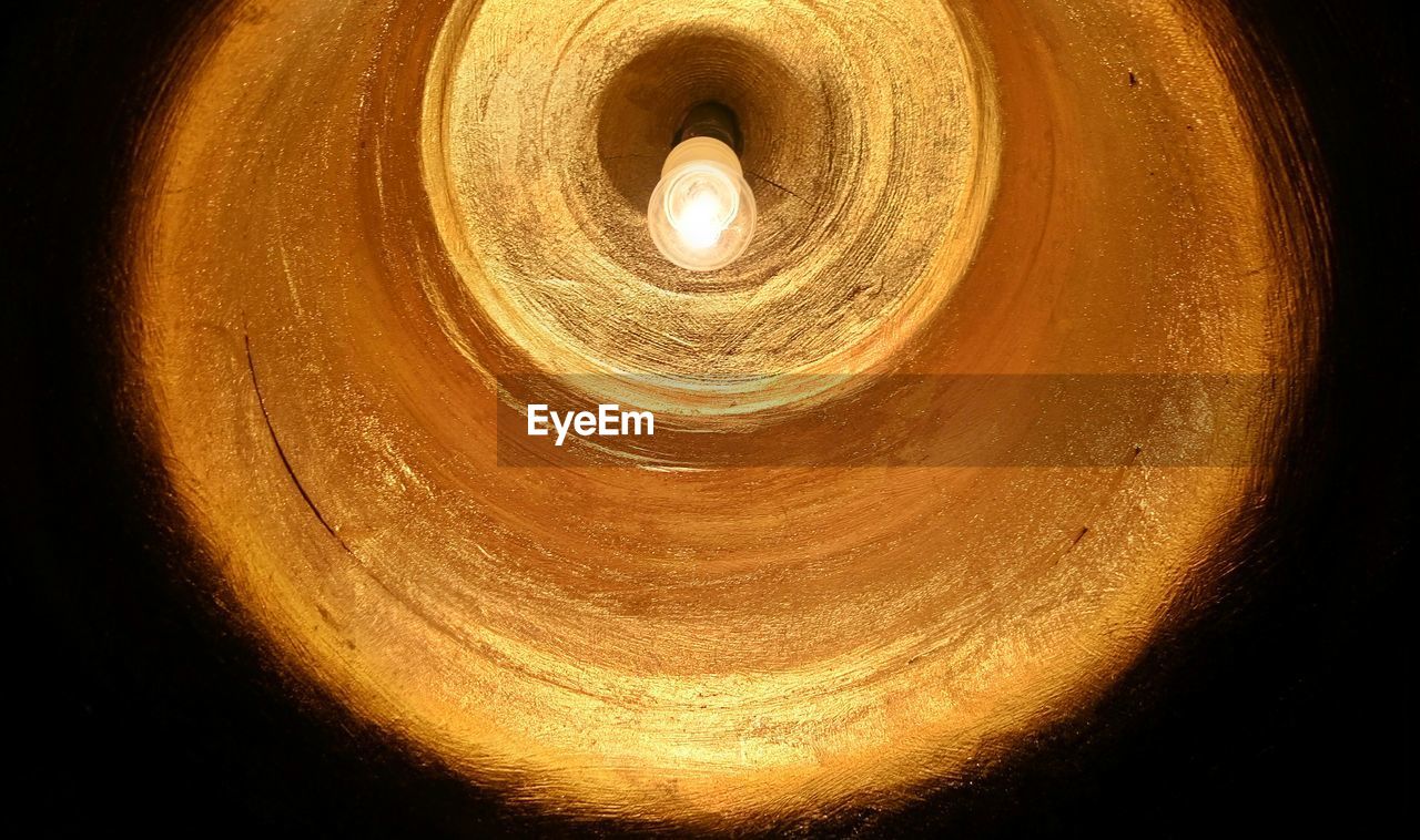 Low angle view of illuminated light bulb at night