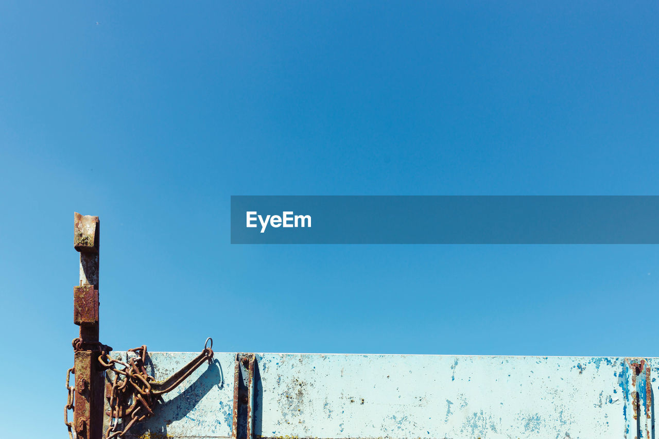 Rusty metal railing against clear blue sky